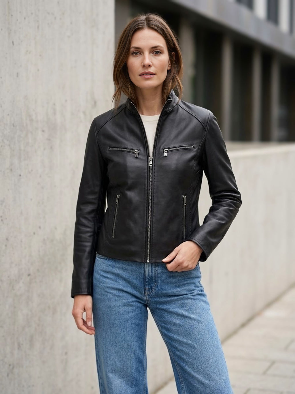 ⁠Giacca da donna in vera pelle nappa nera Made in Italy con collo alla coreana, chiusura zip a vista e quattro tasche con cerniera, indossata con jeans