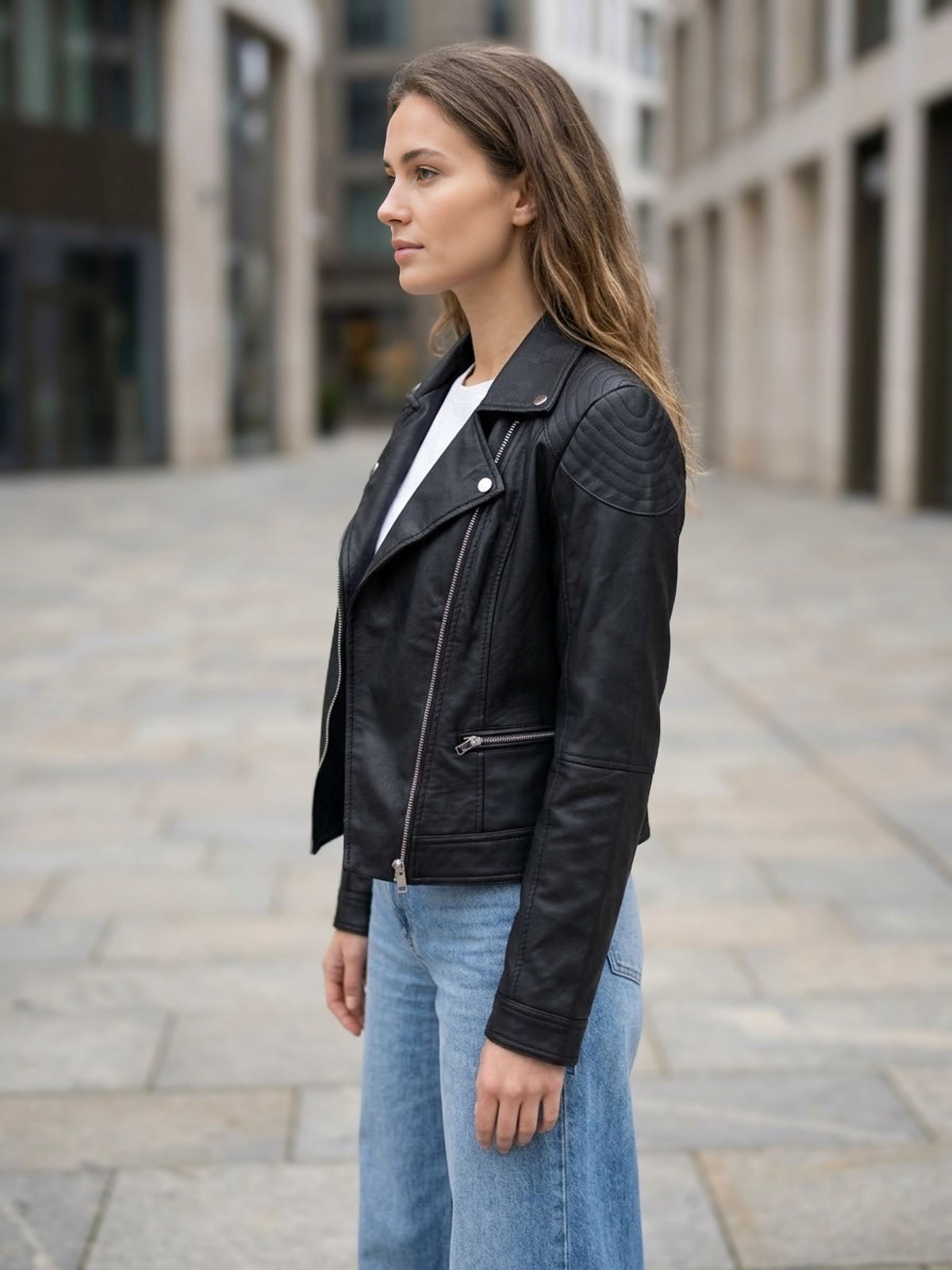 ⁠Giacca biker in ecopelle nera con vestibilità regolare e cerniere metalliche, vista di profilo