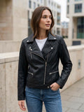 ⁠Giacca chiodo in ecopelle nera da donna con zip asimmetrica argento e dettagli trapuntati sulle spalle, vista frontale intera.⁠