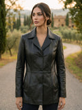 Donna con giacca lunga in vera pelle nappa nera, modello sartoriale artigianale italiano con bottoni.