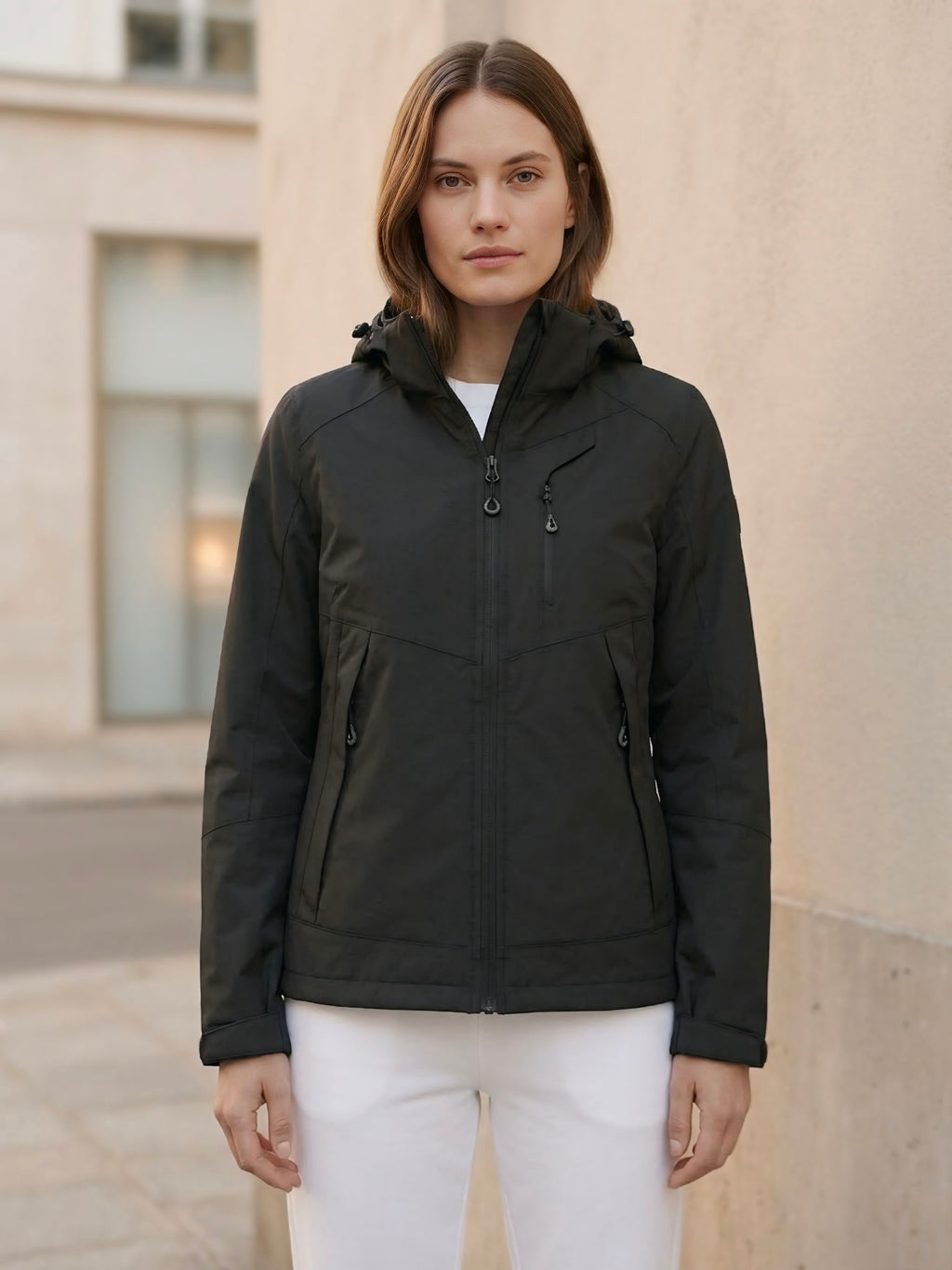Giubbino nero in tela vela ultraleggero con elastici laterali per effetto bomber e cappuccio staccabile.