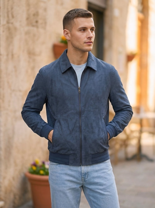 Primo piano di un uomo che indossa un bomber leggero in Alcantara con le mani nelle tasche, evidenziando il tessuto vellutato.